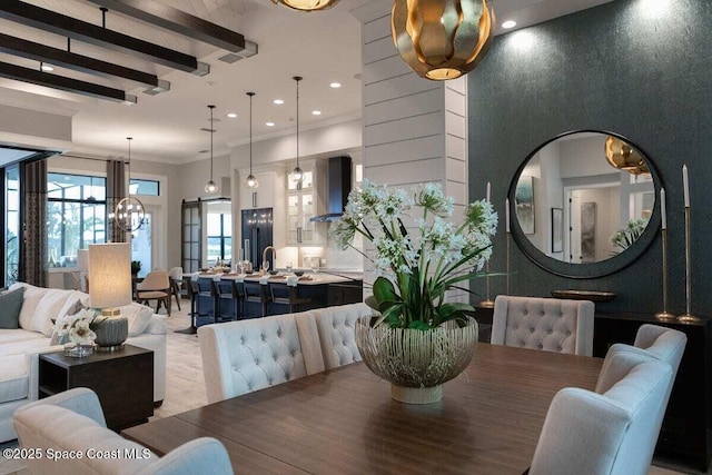 dining space with beamed ceiling, crown molding, and a chandelier