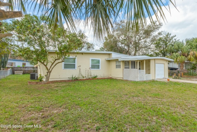 exterior space with a garage, a yard, and central AC unit