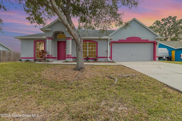 single story home featuring a yard and a garage