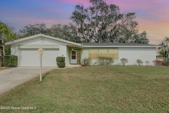 single story home featuring a garage and a lawn