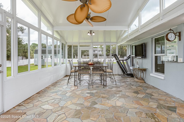 sunroom / solarium featuring vaulted ceiling with beams and a healthy amount of sunlight