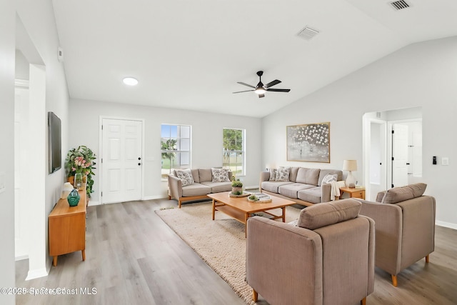 living room with lofted ceiling, ceiling fan, and light hardwood / wood-style flooring