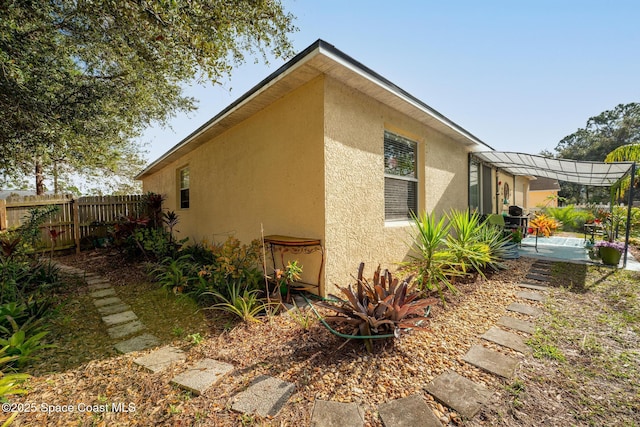 view of property exterior with a pergola and a patio area