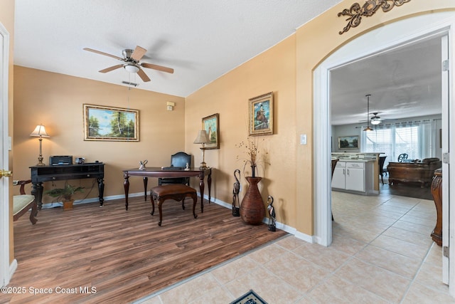 home office featuring ceiling fan, a textured ceiling, and light wood-type flooring