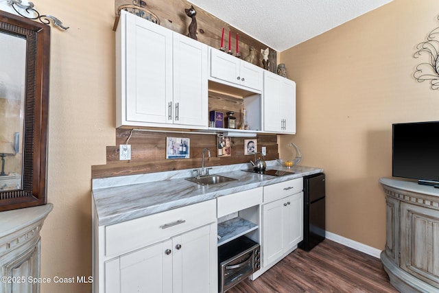 kitchen featuring sink, a textured ceiling, and white cabinets