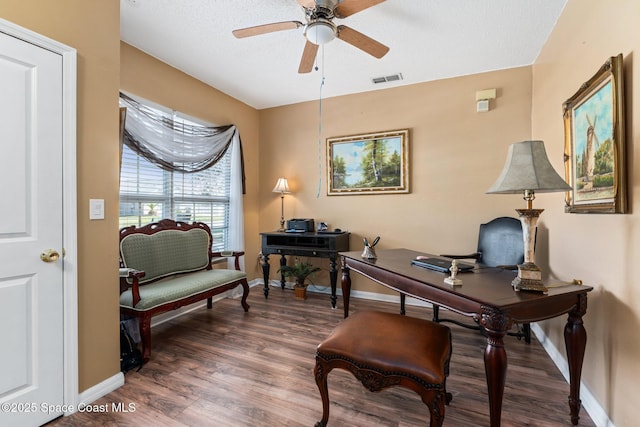 home office with ceiling fan, dark hardwood / wood-style floors, and a textured ceiling