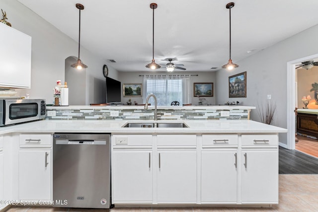 kitchen with sink, hanging light fixtures, white cabinets, and appliances with stainless steel finishes