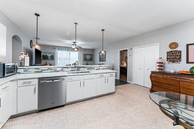 kitchen with sink, pendant lighting, ceiling fan, stainless steel appliances, and white cabinets