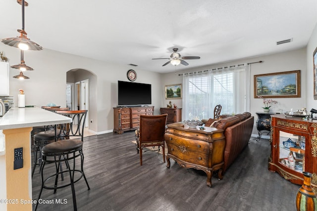 living room with ceiling fan and dark hardwood / wood-style flooring