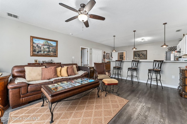 living room with ceiling fan and dark hardwood / wood-style flooring