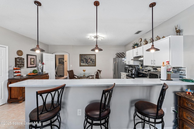 kitchen with pendant lighting, white cabinets, a kitchen breakfast bar, and kitchen peninsula