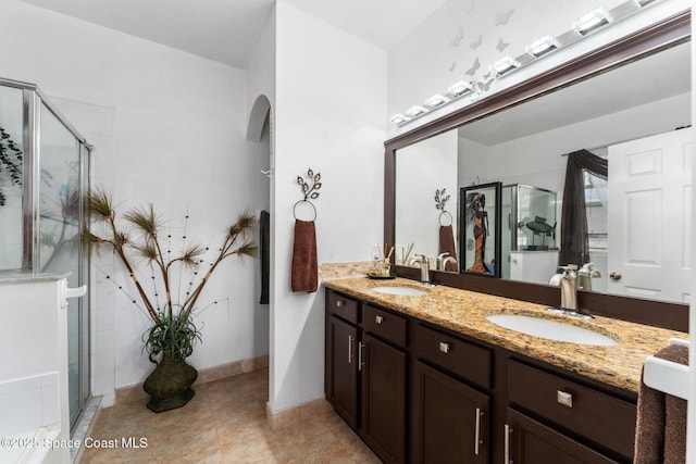 bathroom with vanity, a shower with shower door, and tile patterned flooring