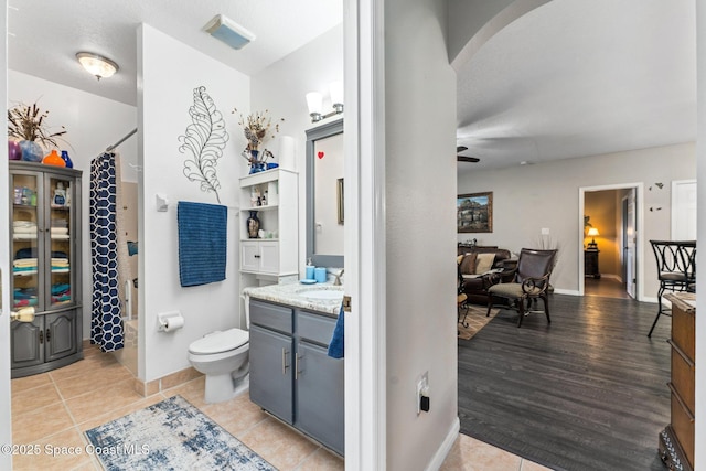 bathroom featuring vanity, tile patterned flooring, toilet, and walk in shower