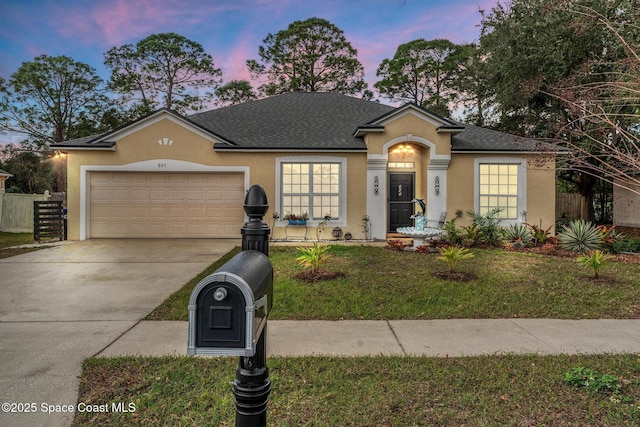 view of front of home featuring a garage and a yard