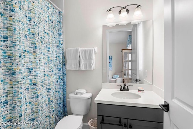 bathroom with vanity, curtained shower, and toilet