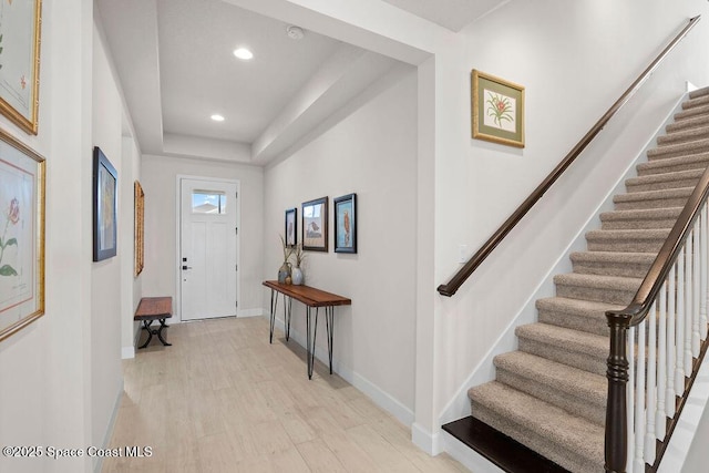 entrance foyer with a raised ceiling and light hardwood / wood-style floors