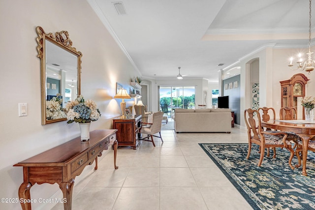 interior space with light tile patterned floors, visible vents, crown molding, and ceiling fan with notable chandelier