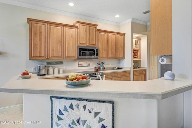 kitchen with stainless steel appliances, light countertops, crown molding, and visible vents