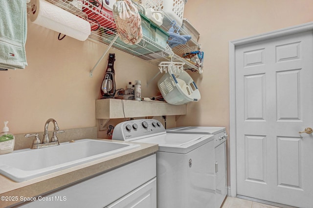 laundry area featuring laundry area, washing machine and dryer, light tile patterned floors, and a sink