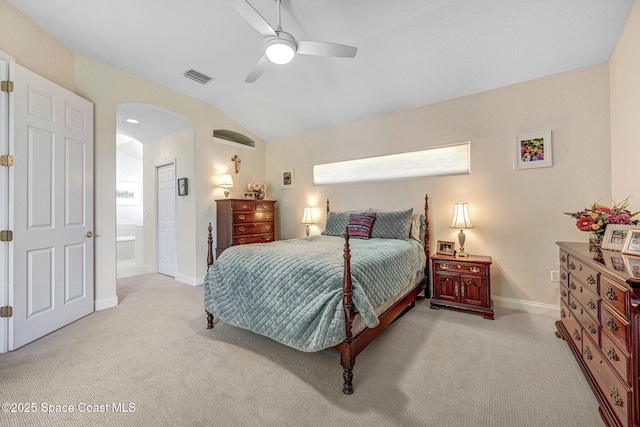 bedroom featuring carpet floors, arched walkways, visible vents, and lofted ceiling