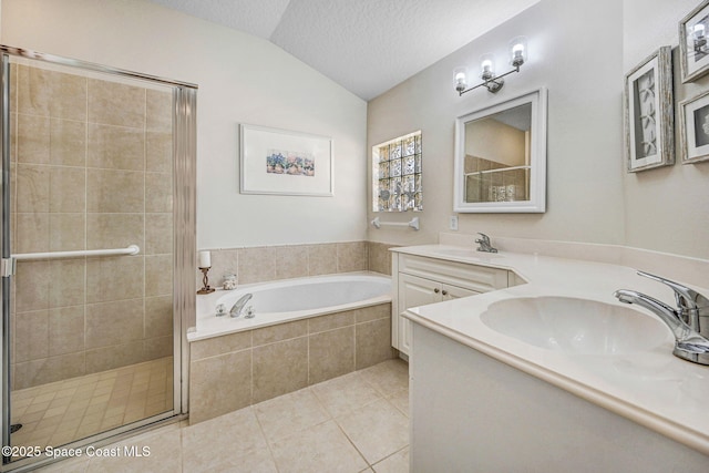 bathroom with a stall shower, lofted ceiling, a garden tub, a textured ceiling, and a sink