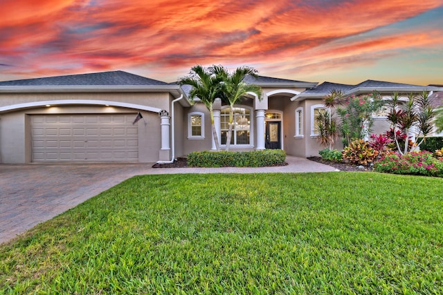 view of front of property featuring a garage and a yard