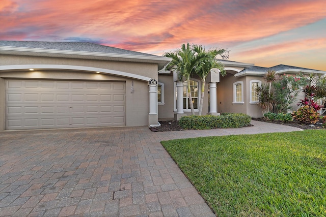 view of front of home with a garage and a yard