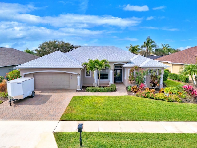 ranch-style home featuring a garage and a front yard