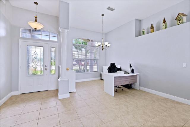 entryway with light tile patterned floors, decorative columns, and a chandelier