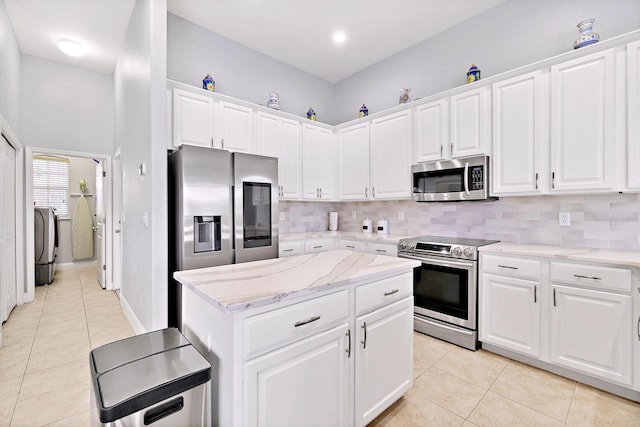 kitchen featuring white cabinetry, independent washer and dryer, stainless steel appliances, and tasteful backsplash