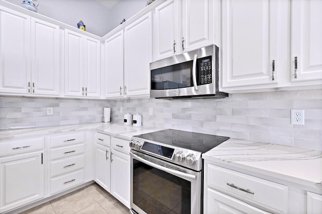 kitchen with white cabinetry, backsplash, light tile patterned flooring, and appliances with stainless steel finishes