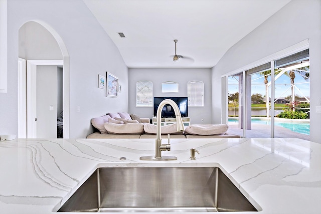 living room featuring lofted ceiling and sink