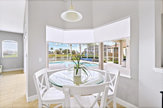 dining space featuring a towering ceiling and tile patterned floors