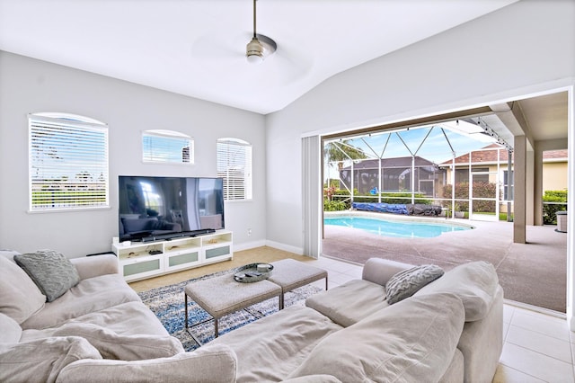 living room featuring a wealth of natural light, light tile patterned flooring, ceiling fan, and vaulted ceiling