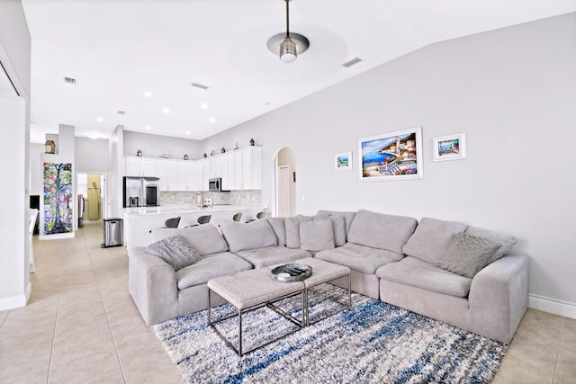 tiled living room featuring lofted ceiling and sink