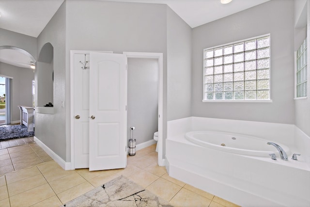 bathroom featuring tile patterned flooring, a bathing tub, and toilet