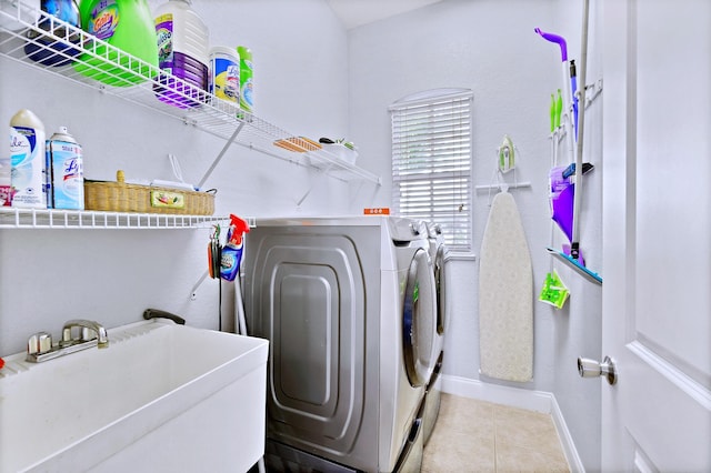 laundry room with sink, light tile patterned floors, and independent washer and dryer