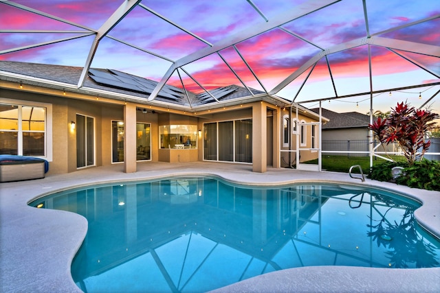 pool at dusk featuring a lanai and a patio