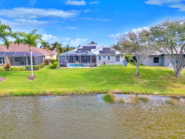 back of property featuring a water view, a yard, and glass enclosure