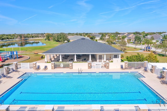 view of swimming pool featuring area for grilling, a patio, a playground, and a water view