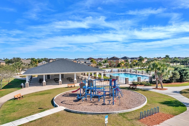 exterior space with a gazebo, a community pool, and a lawn