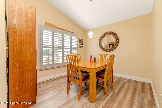 dining area with vaulted ceiling and light hardwood / wood-style flooring