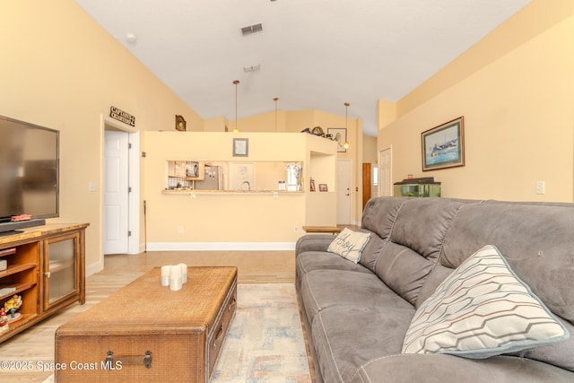 living room with vaulted ceiling and light hardwood / wood-style floors