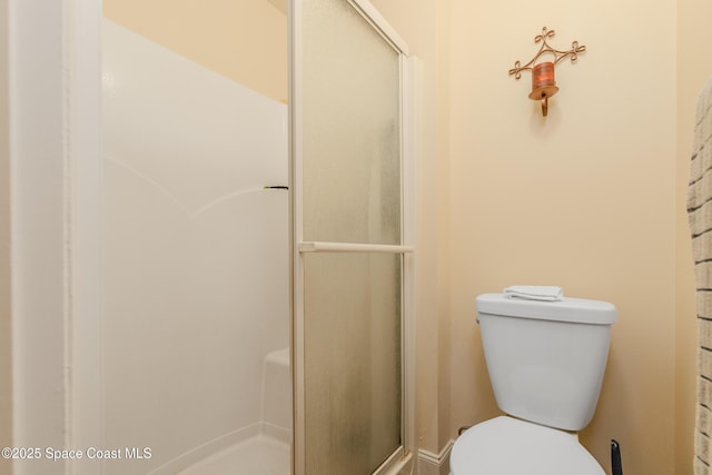 bathroom with toilet and a shower with door