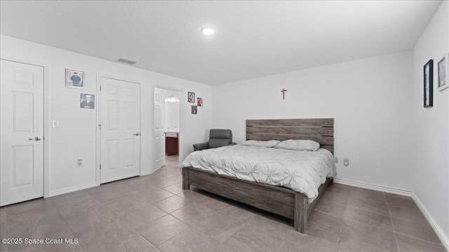 bedroom with connected bathroom and a textured ceiling