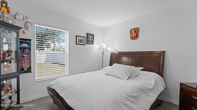 bedroom with light tile patterned floors and a textured ceiling