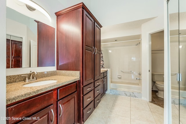 full bathroom featuring tiled shower / bath, vanity, toilet, and tile patterned flooring