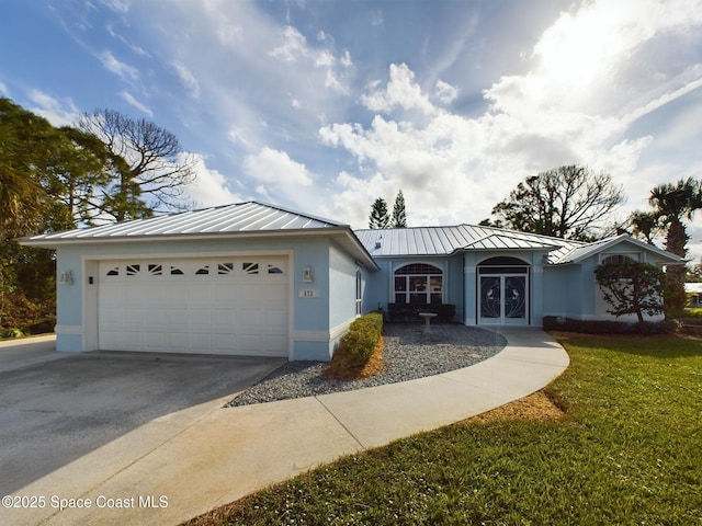 single story home with driveway, metal roof, an attached garage, a standing seam roof, and stucco siding