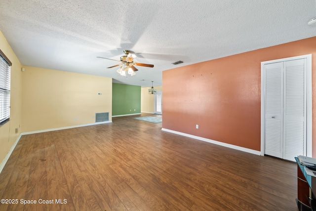 unfurnished living room featuring dark wood-type flooring, ceiling fan, and a textured ceiling