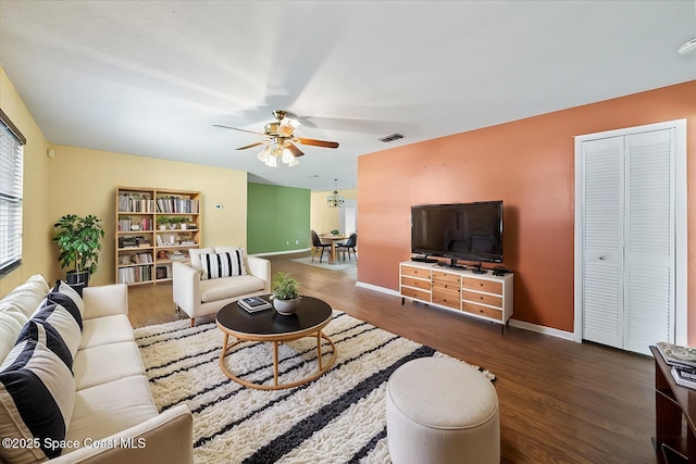 living room with dark wood-type flooring and ceiling fan